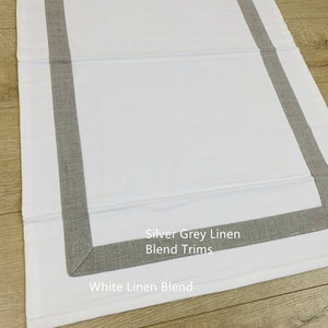 May include: White linen blend fabric with silver grey linen blend trim. "Silver Grey Linen Blend Trims" and "White Linen Blend" are written on the fabric.