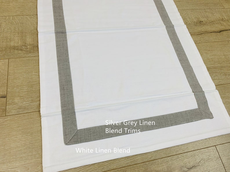 May include: White linen blend fabric with silver grey linen blend trim. "Silver Grey Linen Blend Trims" and "White Linen Blend" are written on the fabric.