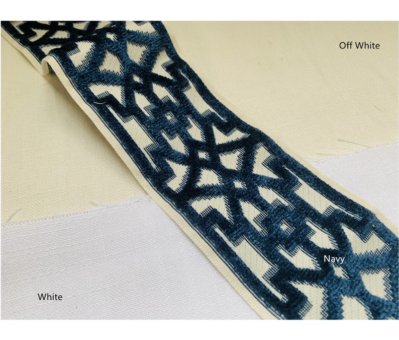May include: A close-up of fabric swatches in off-white, white, and navy blue. The navy blue fabric has a geometric pattern in white.