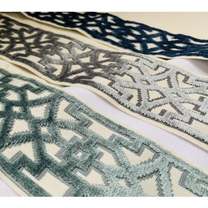 May include: Three different trims with a geometric pattern in shades of blue, gray, and white. The trims are woven with a textured, raised design.