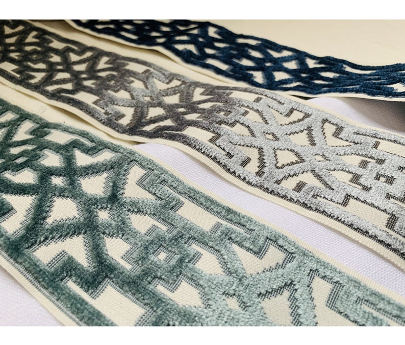 May include: Three different trims with a geometric pattern in shades of blue, gray, and white. The trims are woven with a textured, raised design.
