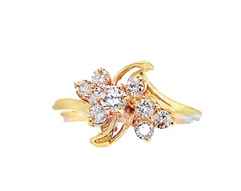 May include: A gold-toned ring featuring a floral design with multiple clear, round-cut gemstones. The ring's band has a flowing, asymmetrical shape, and the gemstones are clustered to resemble a flower.