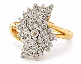 May include: A gold ring featuring a large, asymmetrical cluster of marquise-shaped silver-toned settings, each containing a small round white diamond. The cluster is arranged in a fan-like pattern, mounted on a polished yellow gold band.