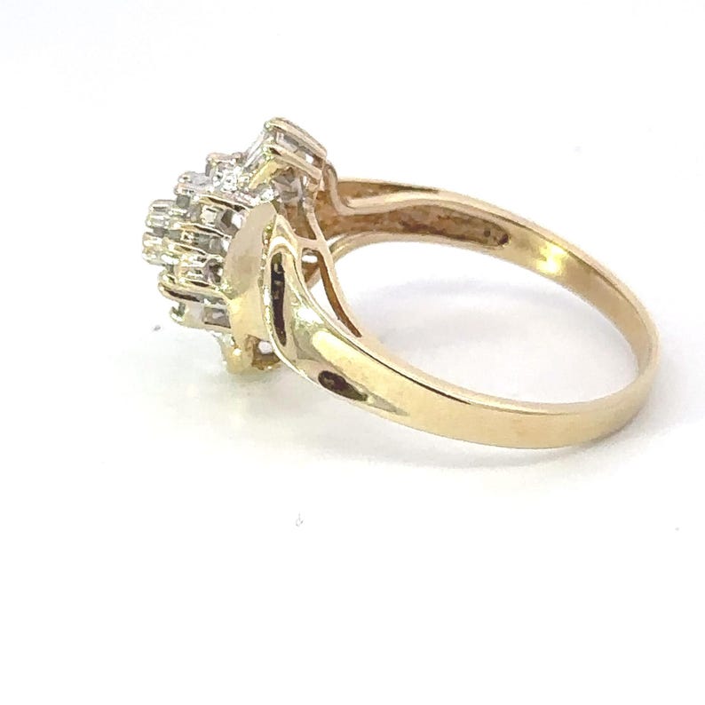 May include: A gold ring with a cluster of small diamonds set in a floral design.