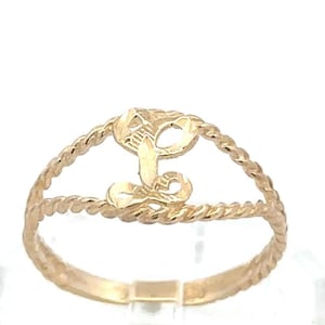 May include: A gold ring featuring a central cursive letter L design. The band is constructed from two twisted rope-style wires that meet at the sides, creating an open space around the letter. The metal has a polished, reflective finish.