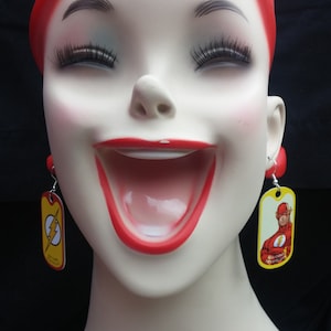 Peut inclure: Un mannequin portant un bandeau rouge et des boucles d'oreilles avec un logo Flash jaune et rouge et une image de personnage Flash jaune et rouge.