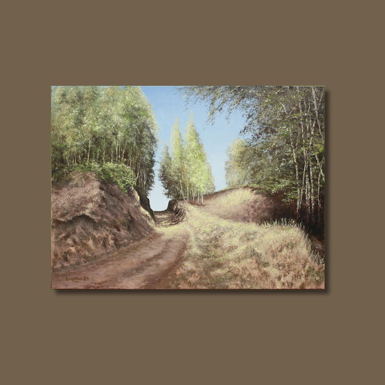 May include: Oil painting of a dirt road winding through a forest. The road is flanked by grassy hills and tall trees with green foliage. The sky is a clear blue, and the artwork is framed in a brown border.