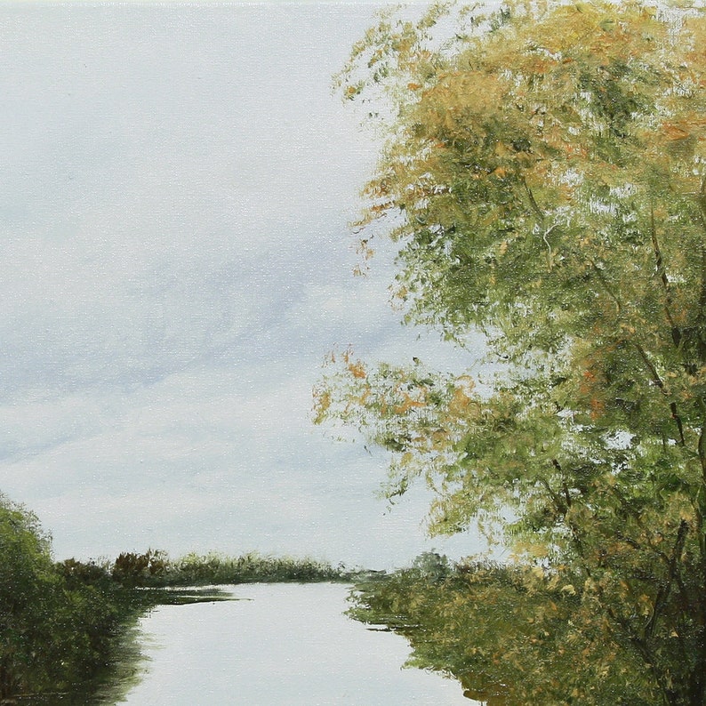 Pu&ograve; includere: Un dipinto a olio raffigura una serena scena fluviale sotto un cielo nuvoloso. Lussureggianti alberi verdi con tocchi di fogliame giallo e marrone incorniciano il bordo dell'acqua. L'opera d'arte evoca un senso di calma e bellezza naturale.