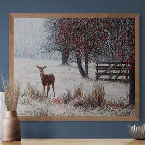 Pu&ograve; includere: Dipinto di paesaggio incorniciato raffigurante un cervo in un campo innevato con alberi e una staccionata di legno. Gli alberi hanno bacche rosse e l'opera &egrave; in una cornice di legno. Il dipinto evoca una scena invernale serena.