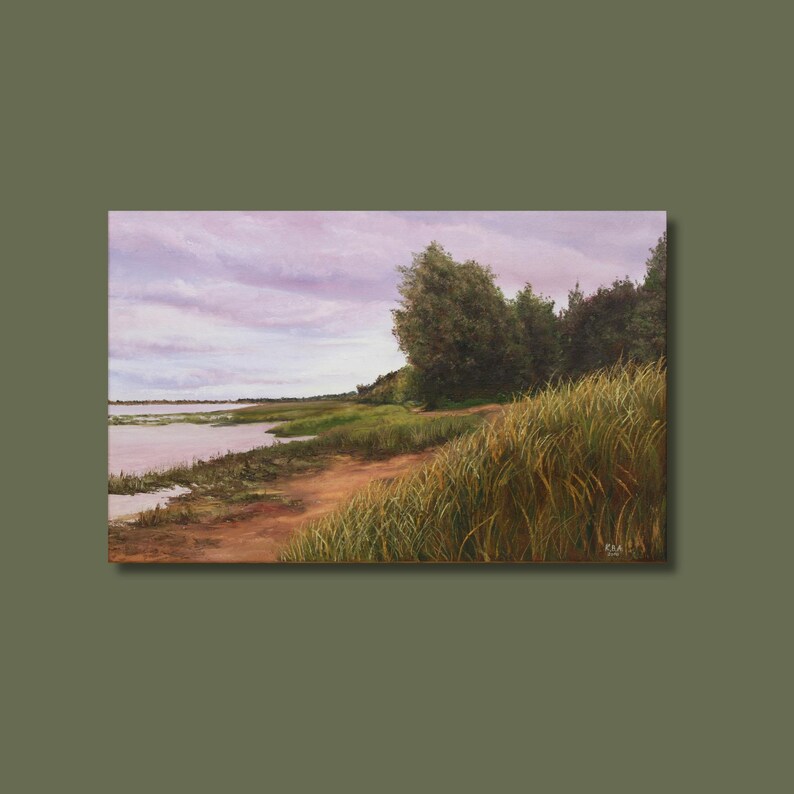 May include: An oil painting shows a tranquil landscape with a river, grassy banks, and trees under a cloudy sky. The artwork uses greens, browns, and purples, capturing a peaceful outdoor scene. The painting is framed and ready to hang.