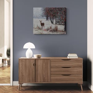 Pu&ograve; includere: Una credenza in legno chiaro con due ante e tre cassetti. Una lampada bianca e una piccola ciotola sono sopra. Un dipinto di un cervo in un campo innevato &egrave; appeso al muro. La credenza &egrave; lunga 150 cm.