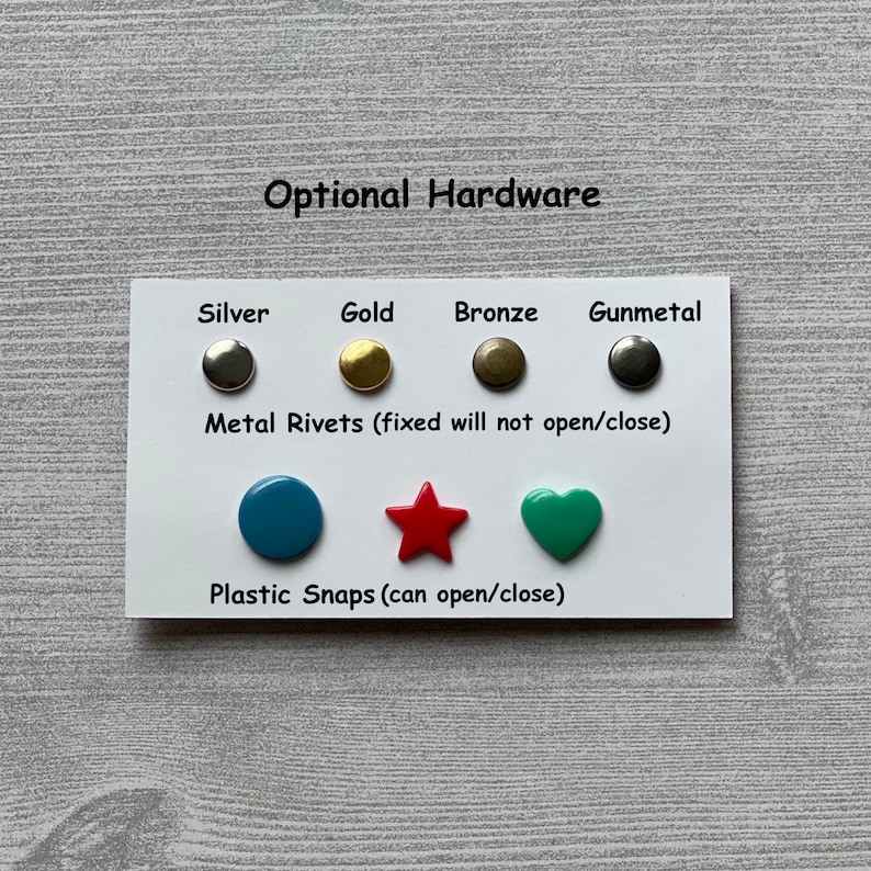 Peut inclure: Une carte blanche avec le texte "Optional Hardware" imprim&eacute; en haut. La carte montre diff&eacute;rents types de rivets m&eacute;talliques et de pressions en plastique de diff&eacute;rentes couleurs. Le texte "Metal Rivets (fixed will not open/close)" et "Plastic Snaps (can open/close)" est imprim&eacute; sous les rivets et les pressions.