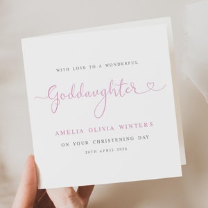 May include: A white card with pink text that reads "With love to a wonderful Goddaughter" and "Amelia Olivia Winters on your christening day 28th April 2024".