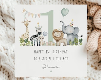 Könnte beinhalten: Geburtstagskarte mit einer Aquarellillustration einer Giraffe, eines Zebras, eines Erdmännchens, eines Löwen und eines Elefanten, die alle Partyhüte tragen. Die Karte lautet "Happy 1st Birthday To A Special Little Boy Oliver."