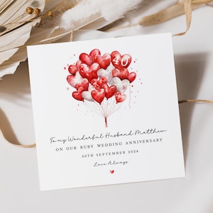 May include: A card featuring a watercolour illustration of red and white heart-shaped balloons with the number 40 in the centre. The text reads "To my Wonderful Husband Matthew On Our Ruby Wedding Anniversary 30th September 2024 Love Always".