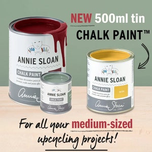 May include: Three tins of Annie Sloan Chalk Paint in different colours: red, green, and yellow. The tins are labelled with the brand name and the text "Chalk Paint". The yellow tin is labelled "Tilton". The text "NEW 500ml tin CHALK PAINT™" is displayed above the tins. The text "For all your medium-sized upcycling projects!" is displayed below the tins.