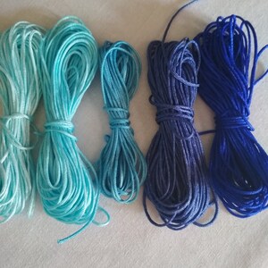 May include: Five spools of embroidery floss in shades of blue, from light blue to dark blue.