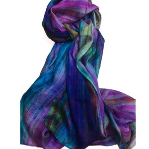 May include: A long, flowing silk scarf with a colorful abstract design in shades of purple, blue, and green. The scarf is made of soft, lightweight silk and is perfect for adding a touch of elegance to any outfit.
