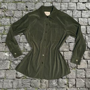 May include: Olive green button-down shirt with long sleeves and two chest pockets. The shirt has a classic collar and buttoned cuffs. The label reads "Classic Editions".