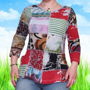 Könnte beinhalten: Ein langärmeliges Oberteil mit Patchwork-Design aus verschiedenen Stoffmustern, darunter rote Blumenmuster, grüne und weiße Streifen, braunes Paisley und abstrakte Formen. Das Kleidungsstück hat einen V-Ausschnitt und sichtbare Nähte zwischen den Stoffbahnen.