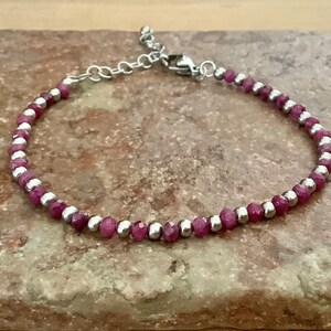 May include: A delicate bracelet made with alternating pink and silver beads. The bracelet has a silver clasp.