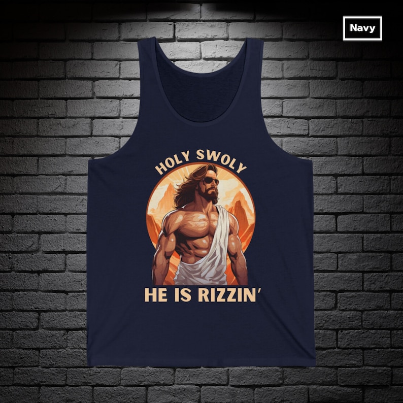 Puede incluir: Una camiseta sin mangas azul marino con un gr&aacute;fico de una figura musculosa de Jes&uacute;s con gafas de sol y el texto "HOLY SWOLY HE IS RIZZIN'" en un c&iacute;rculo.
