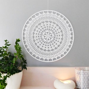 May include: White crocheted wall hanging with a circular design. The hanging is made of delicate lace and has a simple, elegant look.