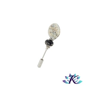 Puede incluir: Un alfiler de plata con una cuenta de vidrio blanca y negra y una cuenta de vidrio blanca y gris más grande. El alfiler es un accesorio decorativo.
