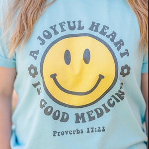 Blij hart is een goed medicijn T-shirt Glimlach Gezicht Trendy christelijk shirt
