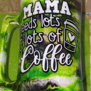May include: A green and white mug with black swirls and glitter. The mug has a handle and says "Mama needs lots & lots of coffee" with a coffee cup graphic.