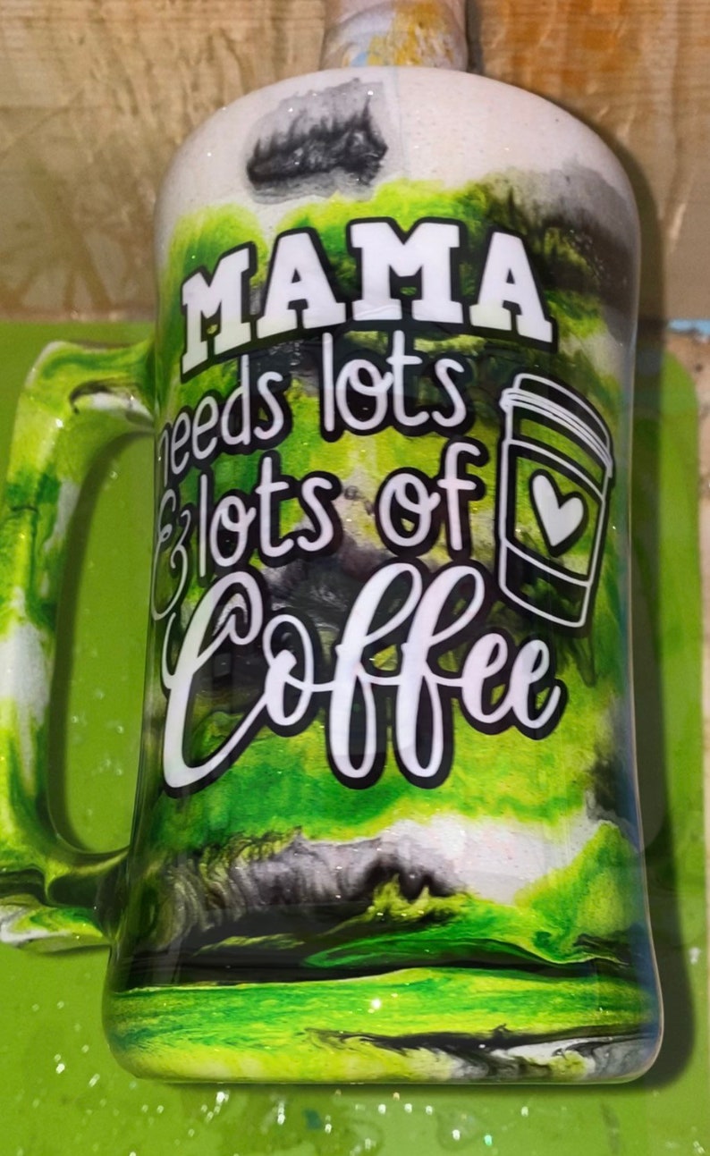 May include: A green and white mug with black swirls and glitter. The mug has a handle and says "Mama needs lots & lots of coffee" with a coffee cup graphic.