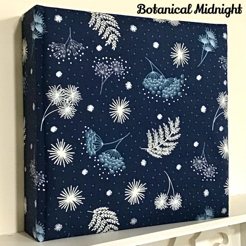 May include: A navy blue fabric square with a white floral pattern and white dots. The fabric has a botanical midnight design.