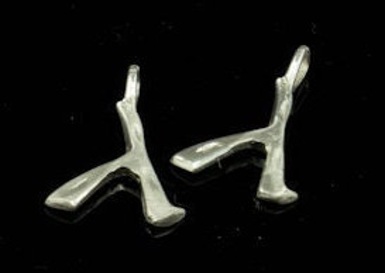 May include: Two silver charms shaped like a stylized axe, each with a loop for attaching to a necklace or bracelet.