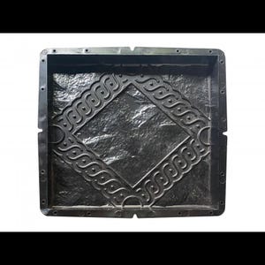 May include: Black plastic mold for creating concrete stepping stones. The mold features a diamond-shaped design with a textured stone pattern and a decorative border.