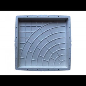 May include: White plastic mold for creating concrete pavers. The mold features a design of a curved pattern of small squares.