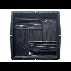 May include: Black plastic mold for creating concrete stepping stones. The mold features a wood plank design with a textured surface.