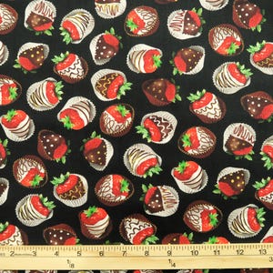 May include: Black fabric with a repeating pattern of chocolate-covered strawberries. The strawberries are red with green leaves and the chocolate is dark brown with white accents.