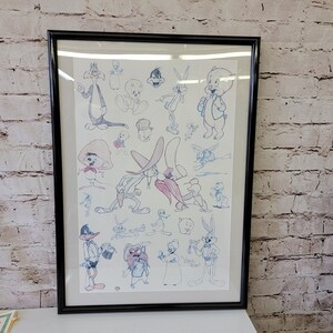 Puede incluir: Una impresión enmarcada que presenta una colección de personajes de dibujos animados, incluyendo Bugs Bunny, Daffy Duck, Tweety Bird y Silvestre el gato. Los personajes están dibujados en blanco y negro con acentos azules y rosas. La impresión está enmarcada en un marco negro.