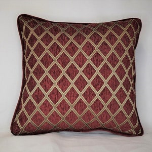 May include: A burgundy and gold decorative throw pillow with a diamond pattern.