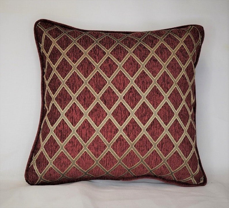 May include: A burgundy and gold decorative throw pillow with a diamond pattern.