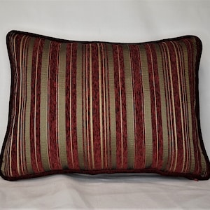 May include: A red and gold striped throw pillow with a dark brown border.