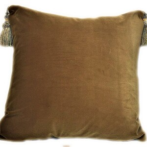 May include: A brown velvet pillow with gold and green tassels on each corner.