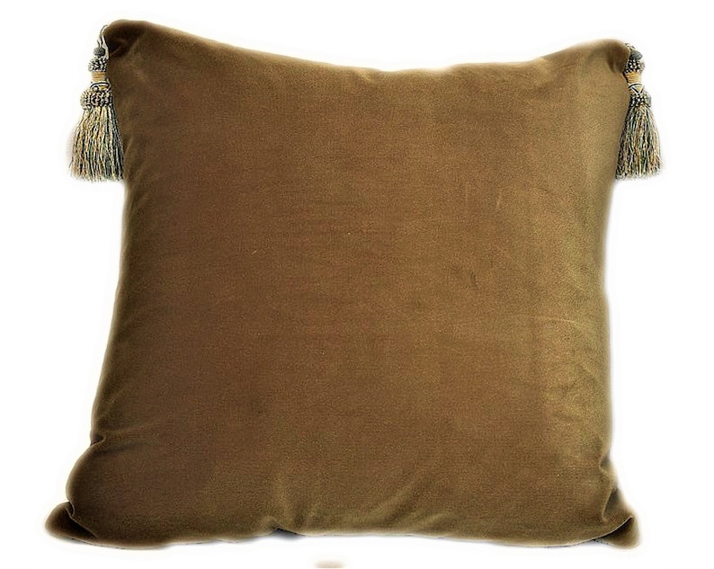 May include: A brown velvet pillow with gold and green tassels on each corner.