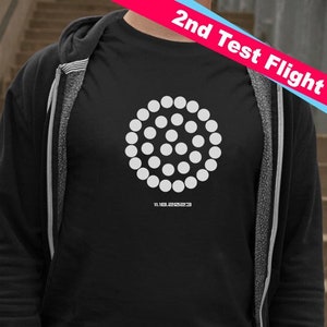 May include: A black long-sleeved shirt with a white circle design featuring a pattern of smaller circles. The text "2nd Test Flight" is in the top right corner of the image. The date "11.18.2023" is printed below the circle design.