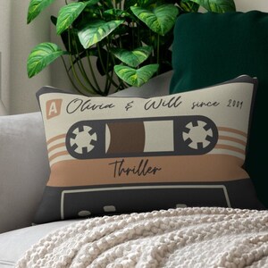 May include: A decorative throw pillow with a vintage cassette tape design. The tape is labeled "Thriller" and has the text "Olivia & Will since 2001" printed on it.