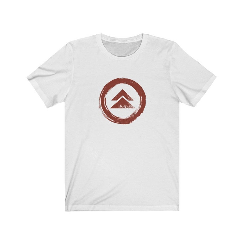 May include: White t-shirt with a red circle and a stylized symbol of two triangles inside. The symbol is a stylized version of the "A" in the logo for the video game Destiny 2.