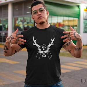 May include: A black t-shirt with a white graphic design of a samurai helmet with antlers. The graphic is centered on the shirt.