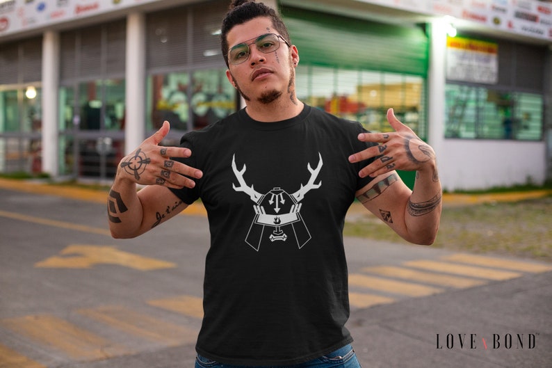 May include: A black t-shirt with a white graphic design of a samurai helmet with antlers. The graphic is centered on the shirt.