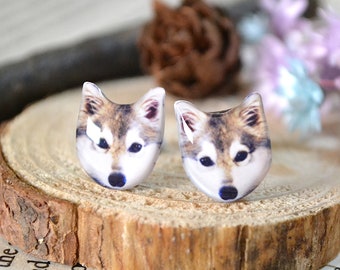 May include: A pair of wolf-themed stud earrings. The earrings are made of white metal and feature a realistic image of a wolf's face.