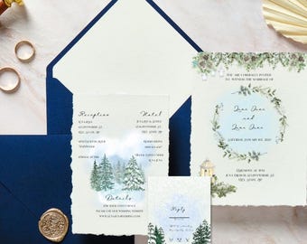 May include: Wedding stationery set with a navy blue envelope, invitation cards, and reply cards. The invitation cards feature a watercolour winter forest design. Gold wedding rings and a wax seal are also visible.